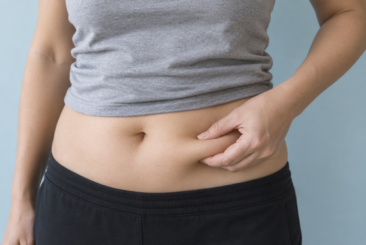 Person gently pinching the skin of the lower abdomen before an injection