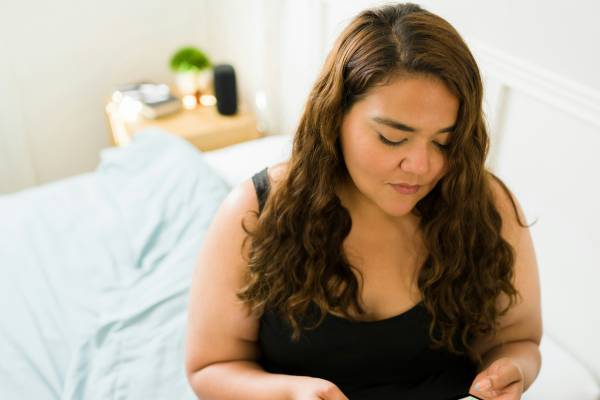 Person resting in bed while reading about Mounjaro side effects