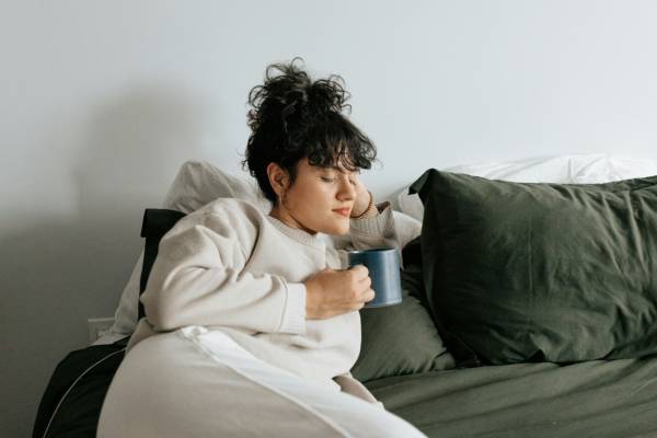 Person on a sofa reading about switching from Mounjaro to Wegovy
